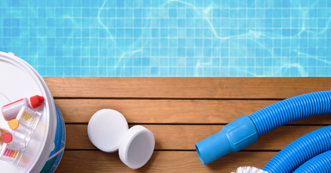 Chemical products and tools for the maintenance of the pool on wooden slats. Pool with water and blue mosaics background. Horizontal composition