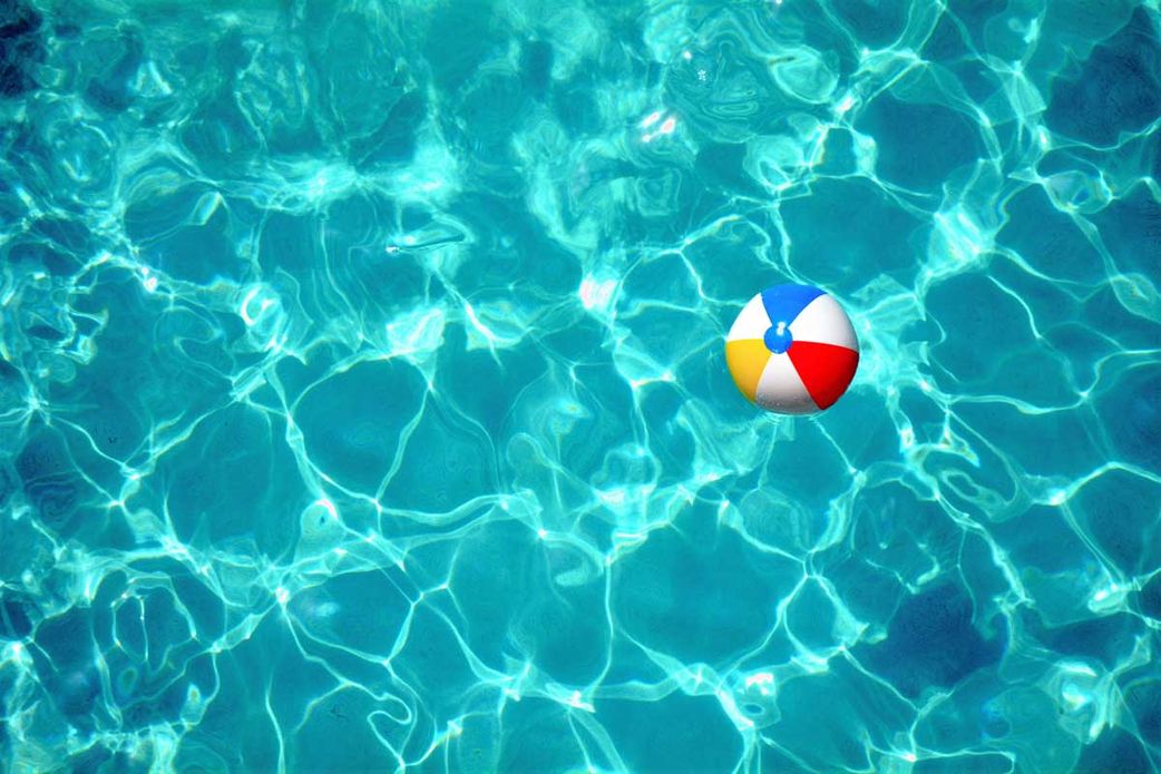 Colorful beach ball in clear blue swimming pool